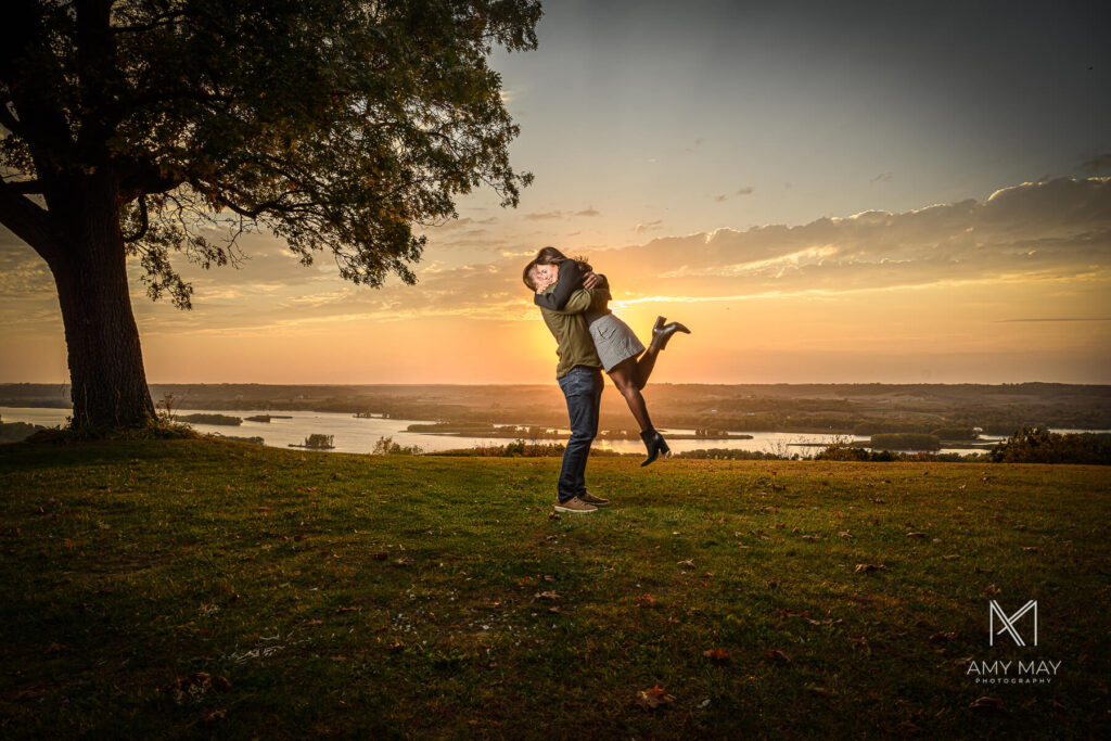 Engaged couple posing at Chestnut Mountain Resort in Galena, IL during golden hour, photographed by Certified Professional Photographer Amy May Laskye